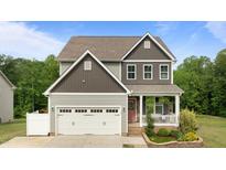 Charming two-story home with a front porch, two-car garage, and beautifully landscaped yard at 55 Prospectus Ln, Franklinton, NC 27525