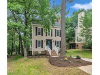 Charming two-story home featuring a well-manicured lawn, complemented by mature trees, and a welcoming front porch at 608 Cross Timbers Dr, Durham, NC 27713