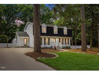 Charming two-story home with black roof, dormers, and a well-manicured lawn at 6709 Sunhaven Pl, Raleigh, NC 27615