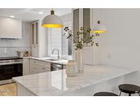 Bright kitchen featuring marble countertops, stainless steel appliances, and pendant lighting at 6709 Sunhaven Pl, Raleigh, NC 27615