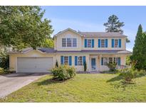 Charming two-story home with blue shutters and a well-manicured lawn, offering classic curb appeal at 7024 Beaverwood Dr, Raleigh, NC 27616