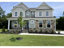 Charming two-story home featuring a landscaped yard, stone accents, and a welcoming front porch at 87 Browning Mill Dr, Wendell, NC 27591
