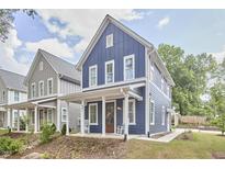 Charming blue two-story home with a welcoming front porch and well-manicured lawn at 941 W Club Blvd, Durham, NC 27701