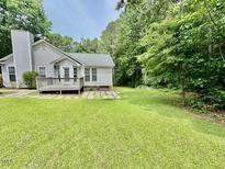 Well-maintained backyard featuring a wooden deck, a large lawn area and mature trees surrounding the property at 1000 Roundtable Ct, Knightdale, NC 27545