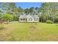 Charming one-story home featuring a landscaped lawn, white siding, and a cozy front porch at 110 Phyllis Dr, Benson, NC 27504