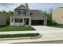 Charming two-story home featuring a covered porch, a spacious two-car garage, and a well-manicured lawn at 1249 Turkey Trot Rd, Wendell, NC 27591