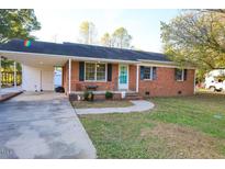 Charming brick home featuring a well-maintained front yard and welcoming entrance with a covered parking area at 130 Church Circle Ln, Bunnlevel, NC 28323