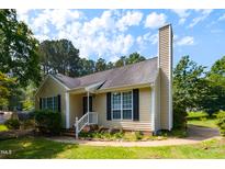 Charming single Gathering home features a manicured lawn and inviting front porch with secure CPI protection at 200 Steeple Rd, Holly Springs, NC 27540
