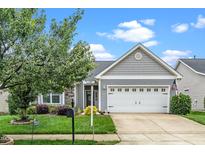 Charming home featuring a two-car garage, stone accents, manicured lawn, and mature landscaping, offering great curb appeal at 2033 Buck Corner Ln, Fuquay Varina, NC 27526