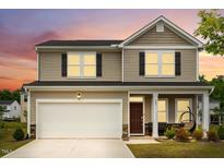 Charming two-story home with a two-car garage and inviting front porch, with fresh landscaping at 209 White Farm Dr, Wendell, NC 27591