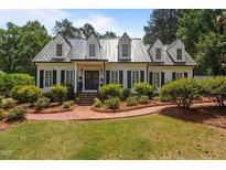 Charming home featuring a brick walkway, manicured landscaping, a metal roof and black shutters at 2190 Keith Hills Rd, Lillington, NC 27546