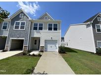 Charming two-story townhome featuring a one-car garage and a well-maintained front yard at 239 Paramount Dr, Smithfield, NC 27577