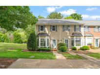 Charming townhouse featuring blue shutters, bay windows, and well-maintained landscaping at 240 Standish Dr, Chapel Hill, NC 27517