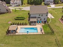 Aerial view of a beautiful backyard pool and lounge area with well-maintained landscaping and privacy fence at 2521 Georgianna Dr, Wake Forest, NC 27587