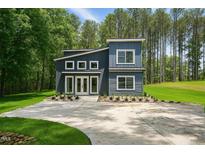 Two-story home featuring board and batten siding, a concrete driveway, and professionally landscaped yard at 2921 Wall Store Rd, Garner, NC 27529