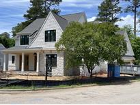 Beautiful new construction home with stone and shingle exterior and black framed windows at 323 Hudson St, Raleigh, NC 27608