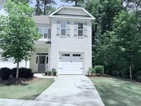 Charming two-story home with white brick and gray shutters, nestled in a lush green neighborhood at 359 Ashton Ridge Ln, Cary, NC 27513