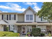 Charming townhome featuring a stone facade and manicured landscaping at 3806 Bison Hill Ln, Raleigh, NC 27604