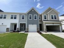 New construction townhomes featuring attached garages, neutral color palettes, and manicured lawns at 381 Thompson Overlook Way, Smithfield, NC 27577