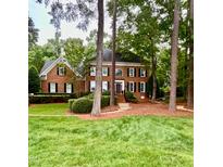 Charming brick two-story home with a well-manicured lawn and mature landscaping at 404 Versailles Dr, Cary, NC 27511