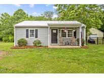 Charming single story home with a manicured lawn and a cozy front porch with rocking chairs at 4048 B S Nc 62 Hwy, Burlington, NC 27215