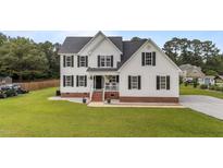 Charming two-story home boasts a well-manicured lawn and classic architectural details, including black shutters at 46 Blaze Ridge Dr, Smithfield, NC 27577