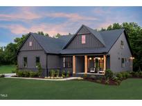 Charming home featuring a covered porch with wooden columns and well-manicured landscaping at 4628 Rogers Rd, Wake Forest, NC 27587
