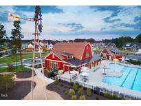 Stunning aerial view of community pool, clubhouse, and windmill amenity at 49 Cozy Hvn, Fuquay Varina, NC 27526