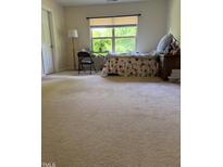 Cozy bedroom with large window providing natural light and a spacious carpeted floor at 525 Abbey Fields Loop, Morrisville, NC 27560