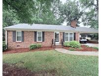 Charming brick home with a carport, well-manicured lawn and established landscaping at 609 Malone Ct, Burlington, NC 27215