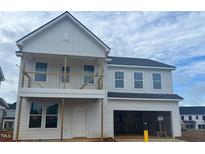 Two-story home showcasing the modern design with neutral siding, covered porch, and an attached two-car garage at 682 Old Station Pointe, Angier, NC 27501