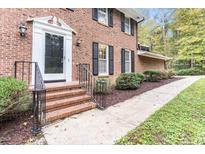 Charming brick home with a classic front entrance and black railing at 6824 Branton Dr, Cary, NC 27519