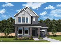 Charming two-story home boasts a modern facade with gray siding, brick accents, and professional landscaping at 92 Restful Pt, Fuquay Varina, NC 27526