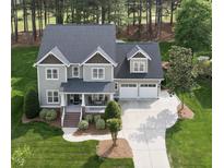 Inviting two-story home with a manicured lawn and a spacious driveway leading to a two-car garage at 925 Hidden Jewel Ln, Wake Forest, NC 27587