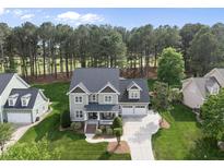 Beautiful two-story home with manicured lawn, mature trees, and an attached two-car garage at 925 Hidden Jewel Ln, Wake Forest, NC 27587