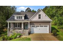 Charming home featuring stone accents, a covered front porch, and an attached two-car garage at 96 Linda Lou Ln, Angier, NC 27501