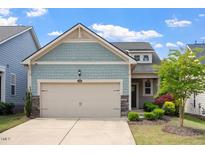 Charming home featuring a two-car garage, stone accents, and delightful landscaping at 1008 Sounding Ln, Durham, NC 27703