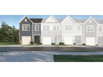 Charming townhome showcasing the exterior with gray siding, black front door and an attached garage at 1105 Weavers Trace Dr, Zebulon, NC 27597