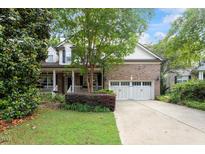 Charming brick home with a manicured lawn, inviting front porch and a two-car garage at 12212 Ashton Woods Ln, Raleigh, NC 27614