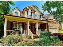 Charming two-story brick home featuring a welcoming front porch and beautiful landscaped yard, plus an attached garage at 12212 Ashton Woods Ln, Raleigh, NC 27614
