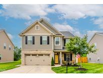 Charming two-story home features a brick and siding exterior with a well-manicured lawn at 123 Claystone Dr, Gibsonville, NC 27249