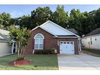 Charming brick home featuring a well-manicured lawn and an attached garage, creating a welcoming curb appeal at 133 Marino Pl, Clayton, NC 27527