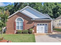 Charming brick home featuring a one-car garage, manicured lawn, and decorative shutters at 133 Marino Pl, Clayton, NC 27527