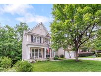 Charming two-story home featuring a welcoming front porch with rocking chairs and a well-manicured lawn at 205 Slate Blue Pl, Cary, NC 27519