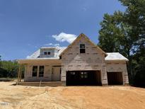 Unfinished new construction home featuring a covered porch and modern roof design at 235 Atkins Rd, Cameron, NC 28326