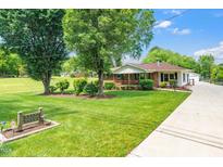 Charming single-story home with a well-manicured lawn, mature trees, and a welcoming front porch at 2925 Redwood Rd, Durham, NC 27704