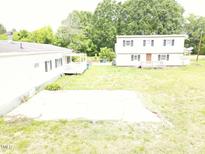 This aerial view shows two homes, with a concrete pad between, and a lush tree line at 3354 Altamahaw Church Rd, Elon, NC 27244