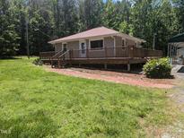 Charming single-story home featuring a spacious wraparound deck and a well-maintained lawn at 3405 Ode Turner Rd, Hillsborough, NC 27278