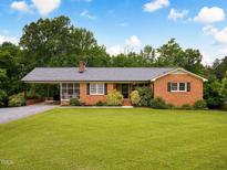 Charming brick home with a well-manicured lawn and covered carport perfect for enjoying the outdoors at 3906 Union Ridge Rd, Burlington, NC 27217