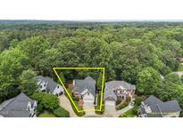 An aerial view shows the home's placement on a wooded lot with an attached two-car garage at 6728 Pointe Vista Cir, Raleigh, NC 27615